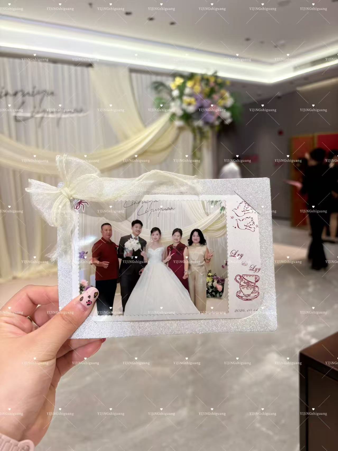 婚礼现场,手中拿着装饰有蝴蝶结的新人亲友合照